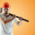 Bearded Man in a helmet holds a sledgehammer on an orange background. Concept of construction, contractor, repair.