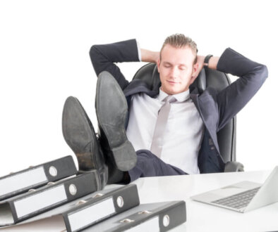 Tired overworked businessman sleeping on the table with laptop a