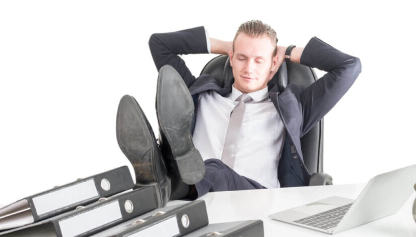 Tired overworked businessman sleeping on the table with laptop a