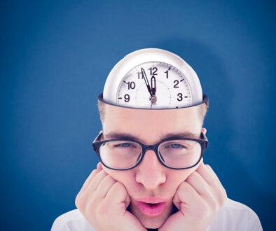 Geeky hipster falling asleep on hands against blue background