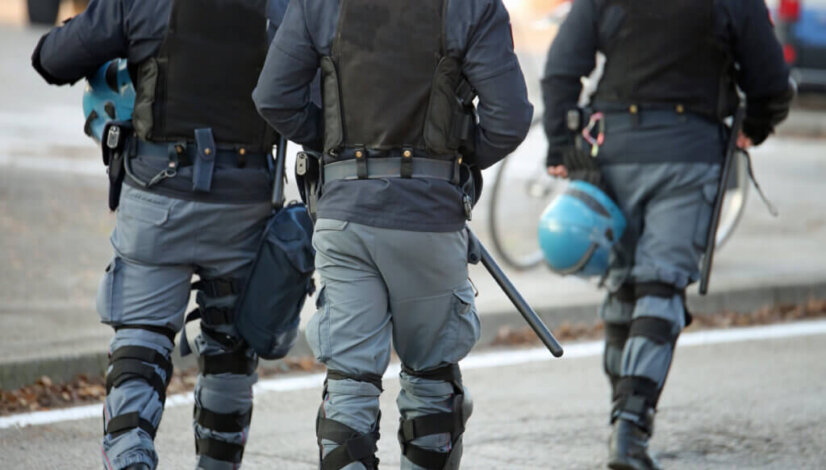 three policemen with anti-bulletproof jacket in anti-riot unifor