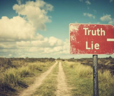 Road sign with "Truth" and "Lie" directions in rural area