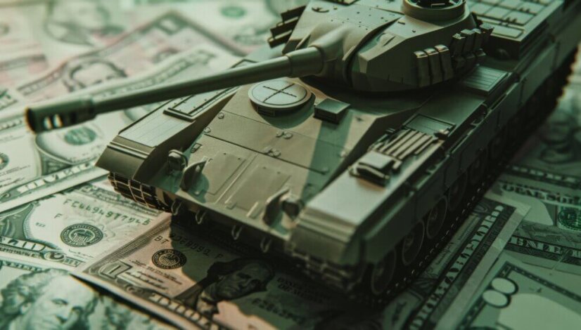 A small model tank is positioned on top of U.S. dollars, symbolizing the close relationship between finance and military power.